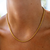 thin rope chain on a tan neck